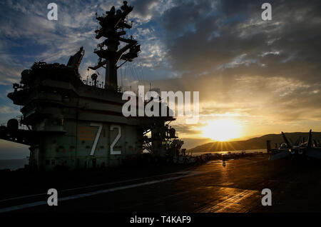 190415-N-GD018-2020 MER MÉDITERRANÉE (15 avril 2019) Le soleil se couche comme la classe Nimitz porte-avions USS ABRAHAM LINCOLN (CVN 72) est ancré au large de Palma de Mallorca, Espagne. Abraham Lincoln est déployée dans le cadre de l'Abraham Lincoln à l'appui des efforts de coopération en matière de sécurité maritime aux États-Unis 5e, 6e et 7e flotte secteurs d'opération. Avec Abraham Lincoln comme le fleuron du groupe, mis en grève les biens comprennent les états-majors, les navires et aéronefs de Carrier Strike Group (CSG), 12 (escadron de destroyers) 2, le croiseur lance-missiles USS Leyte Gulf (CG 55) et Location Banque D'Images