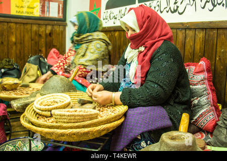 Les femmes marocaines à Marrakech argan craquage pour produire de l'huile d'Argan Noix par la méthode traditionnelle Banque D'Images