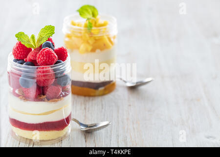 Mangue et framboise dessert, gâteau au fromage, bagatelle, la souris dans un bocal en verre sur un fond de bois Banque D'Images