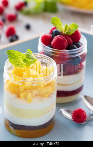 Mangue et framboise dessert, gâteau au fromage, bagatelle, la souris dans un bocal en verre sur un fond de bois, composition verticale Banque D'Images