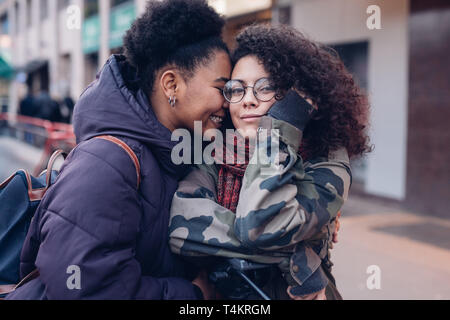 Deux jeunes femmes serrant dans la rue et avoir Se détendre - gai, de la jeunesse, de l'amitié Banque D'Images