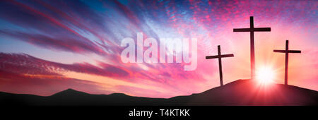 Trois croix de bois sur la colline du Calvaire au lever du soleil - la crucifixion et la résurrection de Jésus Christ Concept Banque D'Images