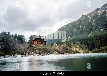 Un abri en bois chaleureux illuminé par le lac Morskie Oko dans les montagnes Tatras, Pologne Banque D'Images