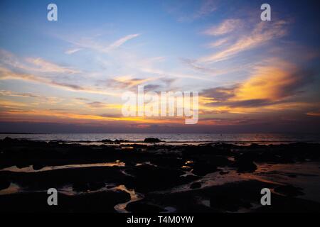 Ciel avec des nuages suspendus et les boues humides durant la marée basse couverte de jaune et rouge, la lumière vive pendant le coucher du soleil on tropical island Ko Lanta, Th Banque D'Images