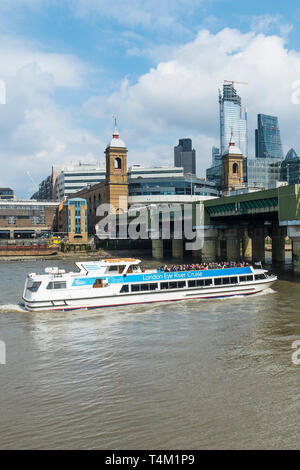 Un bateau de tourisme du London Eye River Cruise passant sous le pont de la rue Cannon sur la Tamise à Londres. Banque D'Images