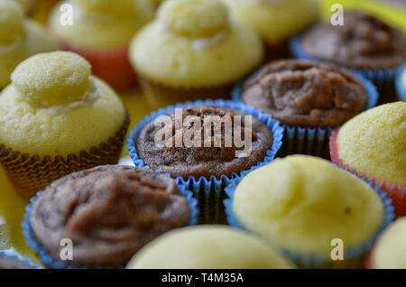 Un bac plein de petits gâteaux. Une rangée de chocolat blanc central, et d'autre avec et sans la couverture hat. Arrière-plan flou. Banque D'Images