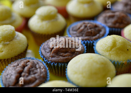 Un bac plein de petits gâteaux. Une rangée de chocolat blanc central, et d'autre avec et sans la couverture hat. Arrière-plan flou. Banque D'Images