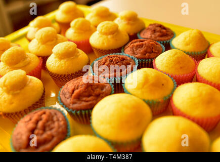 Un bac plein de petits gâteaux. Une rangée de chocolat blanc central, et d'autre avec et sans la couverture hat. Arrière-plan flou. Banque D'Images