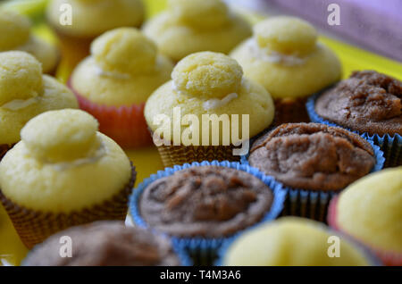 Un bac plein de petits gâteaux. Une rangée de chocolat blanc central, et d'autre avec et sans la couverture hat. Arrière-plan flou. Banque D'Images