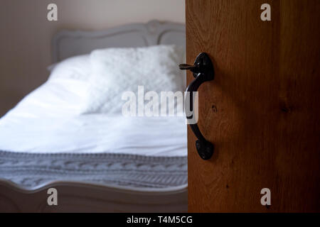 Une chambre tranquille vue par Ajar porte rustique en bois avec poignée Antique Banque D'Images