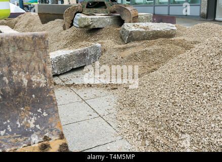 Vue détaillée de la construction d'un mur en pierre de granit rouge avec lors d'un travail de construction du paysage au moyen d'une excavatrice et déplacer le collier de grosses pierres Banque D'Images