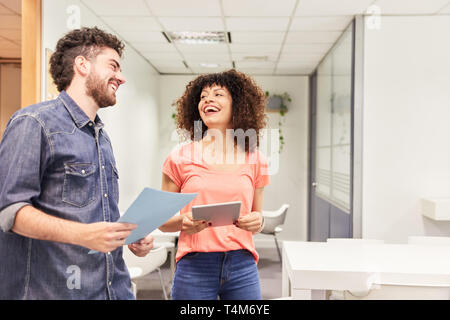 Deux jeunes collègues d'affaires dans le bureau en coworking flirtent et rire Banque D'Images