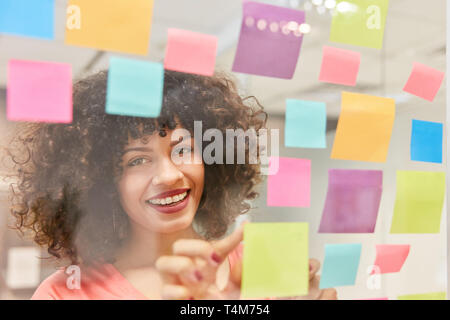 Jeune femme d'affaires en création atelier de réflexion avec des notes adhésives Banque D'Images