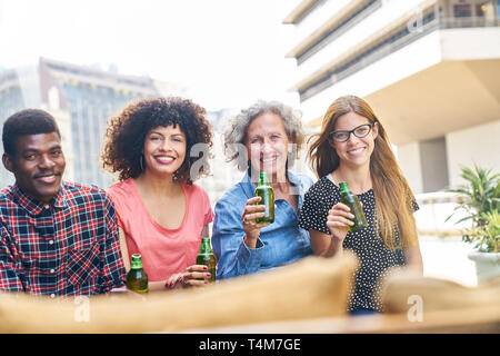 Amis ou collègues de boire une bière après le travail sur le toit Banque D'Images