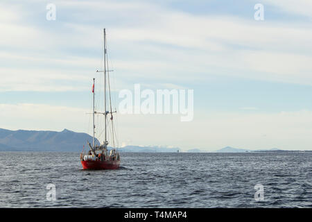 Un bateau à voile rouge contre une montagne, Norvège Banque D'Images