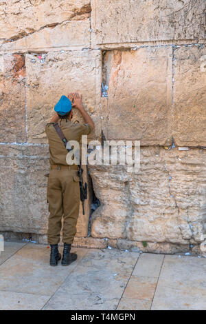 Jérusalem, Israël,29-mars-2019:soldat israélien prie au Mur occidental (Mur des lamentations) à Jérusalem, Israël prières sur morceaux de papier sont farcies entre les pierres Banque D'Images