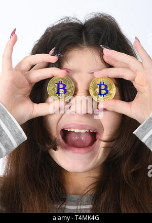 Jolie fille conserve l'oeil au lieu de deux mains en bitcoin cryptocurrency d'or sur fond blanc Banque D'Images