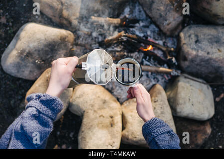 En plein air libre de droit horizontal de jeune femme verse lui-même boisson chaude à proximité de joie. Une jeune femme boit touristique une boisson chaude dans une tasse et bénéficie d''nat Banque D'Images