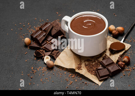 Tasse de chocolat chaud et des morceaux de chocolat noir sur fond de béton Banque D'Images