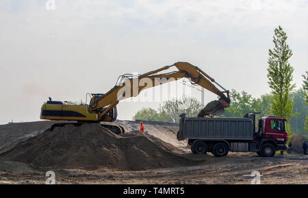 Chargement pelle sable dans le chariot sur la construction de routes d'accès pour le pont Banque D'Images