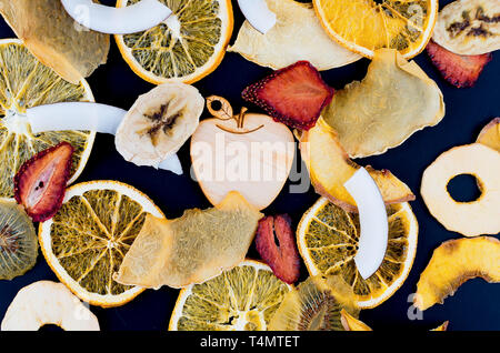 De nombreux fruits varietty plaquettes fixées éparpillés sur fond noir , concept de vie saine et une bonne nutrition, snack, vue du dessus, copy space Banque D'Images