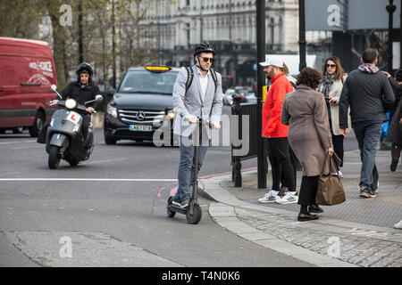 Les navetteurs urbains à l'aide des scooters électriques à Hyde Park Corner Electric comme ministres envisagent de renverser une décennie d'interdiction sur les scooters électriques. Banque D'Images