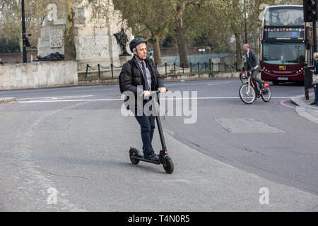 Les navetteurs urbains à l'aide des scooters électriques à Hyde Park Corner Electric comme ministres envisagent de renverser une décennie d'interdiction sur les scooters électriques. Banque D'Images