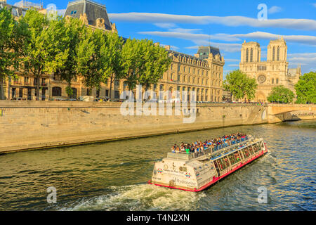 Paris, France - 1 juillet 2017 : Bateaux-Mouches avec beaucoup d'au cours d'un voyage au coucher du soleil sur la Seine avec Notre Dame de Paris sur l'Ile de la Banque D'Images