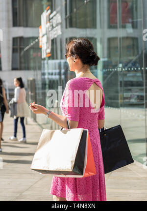 Une femme asiatique shopping avec de nombreux sacs à main. Banque D'Images