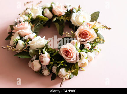 Fausse couronne rose rose sur un fond rose avec des feuilles de faux - close up Banque D'Images