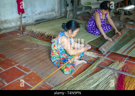 Sadec, Vietnam - 7 mars 2019 : femme de nattes de roseau traditionnel sur tisser dans village rural dans le Delta du Mékong au Vietnam. Banque D'Images