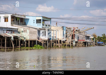 À Cai Be, Vietnam - 8 mars 2019 - Maisons traditionnelles et les bateaux sur le bord de mer de Cai Be au Delta du Mékong du Vietnam. Banque D'Images