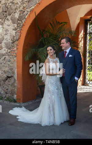 Mariée et le marié dans une cour en pierre après leur cérémonie de mariage Banque D'Images