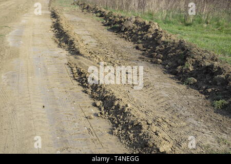 Route de terre nivelée par un classificateur. Dans le village de la route Banque D'Images