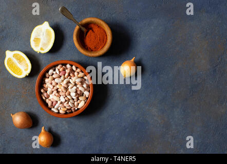 Prebranac ingrédients. Des haricots des Balkans. Le serbe, bosniaque, croate, monténégrin et cuisine slovène. Les haricots crus, oignon, citron, paprika en poudre Banque D'Images