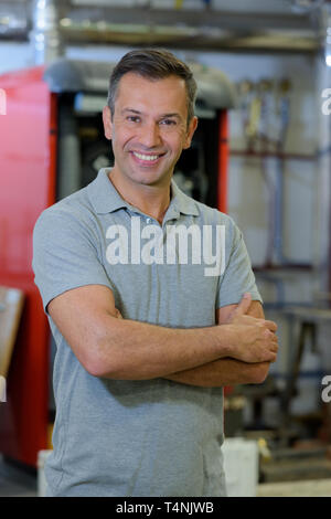 Réparateur en uniforme avec bras croisés Banque D'Images