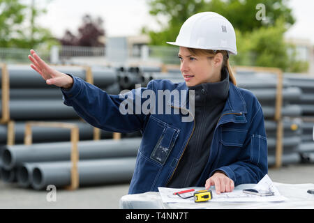 Jeune femme dans une usine de tuyaux de ventilation Banque D'Images