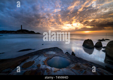 Avis de Ke Ga phare au coucher du soleil avec les nuages magiques. Phare de Ke Ga est situé sur une petite île dans la province de Ninh Thuan, Vietnam Banque D'Images