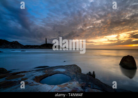 Avis de Ke Ga phare au coucher du soleil avec les nuages magiques. Phare de Ke Ga est situé sur une petite île dans la province de Ninh Thuan, Vietnam Banque D'Images