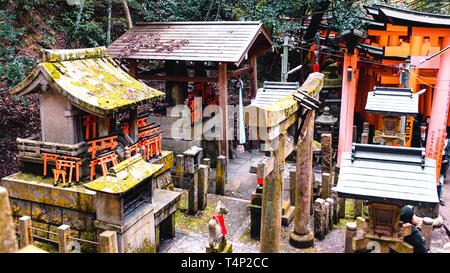 Portes Orange et des objets au Sanctuaire Fushimi Inari-Taisha culte à Kyoto, Japon Banque D'Images