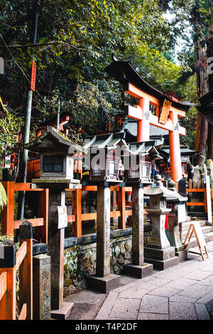 Portes Orange et des objets au Sanctuaire Fushimi Inari-Taisha culte à Kyoto, Japon Banque D'Images