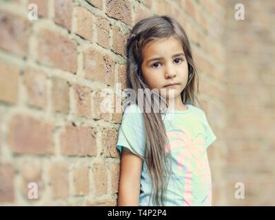 Fille, 5 ans, appuyé contre un mur, portrait, Allemagne Banque D'Images