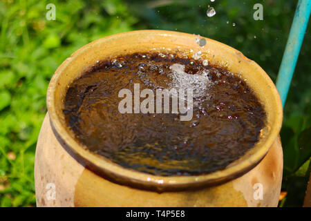 Fuite de l'eau passant d'un robinet d'eau en vintage jarre Banque D'Images