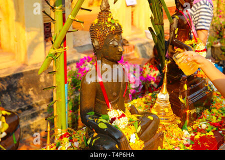 Statues de Bouddha d'arrosage avec l'eau parfumée et de pétales de fleurs au cours de la nouvelle année - Mai Rp - Lao Song Kran - Fête de l'eau en Avril Banque D'Images