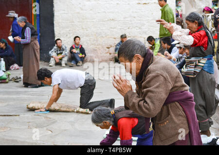 Les pèlerins priant à l'extérieur du Temple du Jokhang, le temple le plus sacré du bouddhisme tibétain à Lhassa, Tibet Banque D'Images