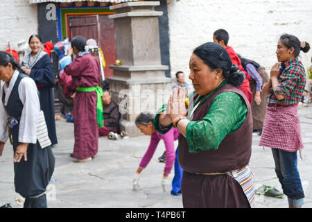 Les pèlerins priant à l'extérieur du Temple du Jokhang, le temple le plus sacré du bouddhisme tibétain à Lhassa, Tibet Banque D'Images