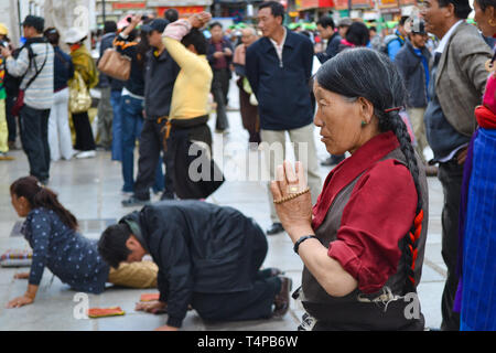 Les pèlerins priant à l'extérieur du Temple du Jokhang, le temple le plus sacré du bouddhisme tibétain à Lhassa, Tibet Banque D'Images