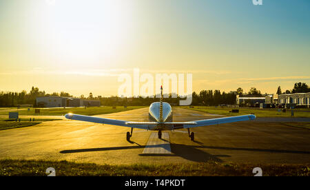 Petit avion prêt à décoller à l'aéroport au lever du soleil. Banque D'Images