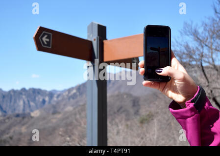 Tourist se demandent quelle voie mène à l'attraction touristique. Hand holding up smartphone pour prendre une photo. Photo prise à la Grande Muraille à Beijing, Chine Banque D'Images