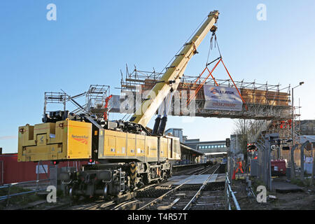 Un chemin de fer-grue Kirow monté sur un échafaudage temporaire passerelle en place à la gare de Feltham, Middlesex durant un week-end fermeture de la voie ferrée. Banque D'Images